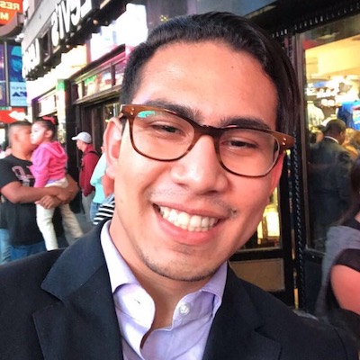 Smiling man wearing glasses in Times Square.