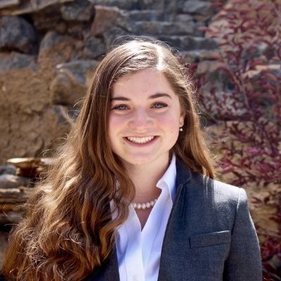 Woman with long brown hair in a blazer.