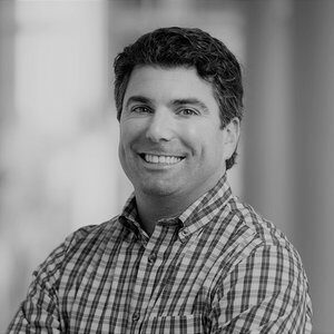 Here's an alt tag for the image: `Headshot of a smiling man`