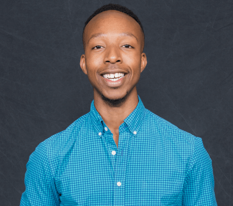A man in blue shirt smiling for the camera.
