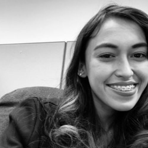 A woman smiling for the camera in black and white.