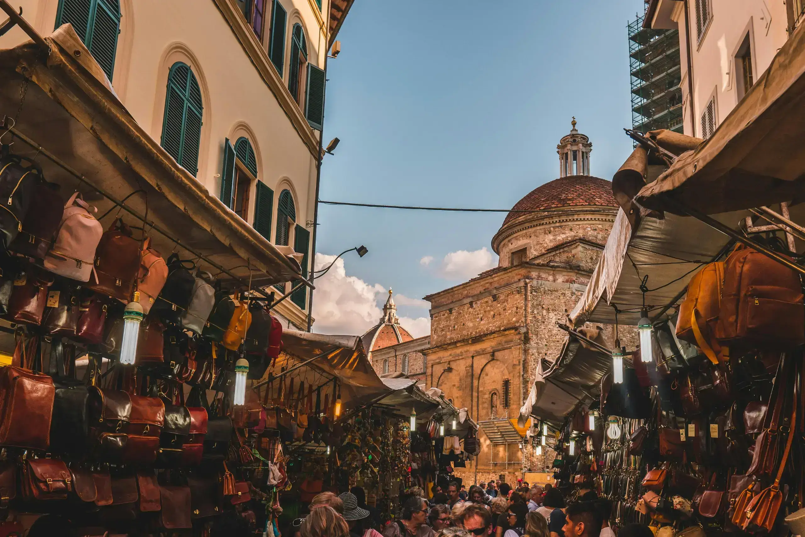 Bustling market street with historic dome background.