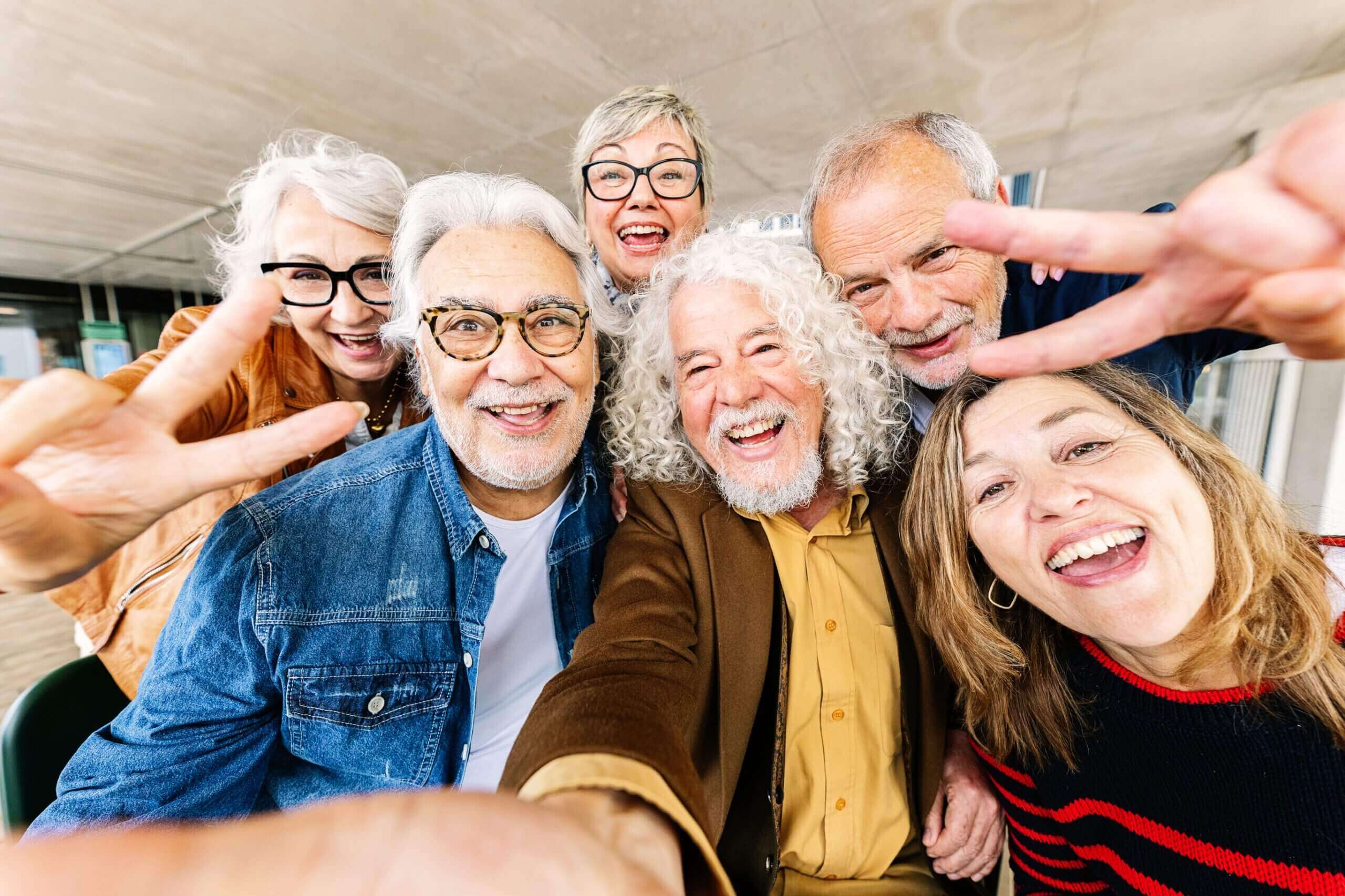 Group of smiling seniors taking a selfie.