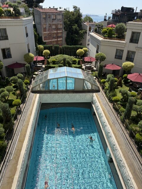 Elegant hotel pool surrounded by lush gardens.