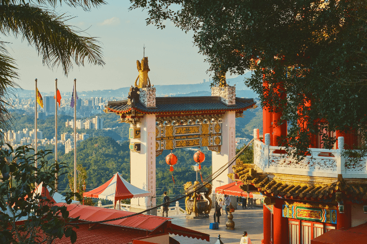 Chinese temple with city view and flags.