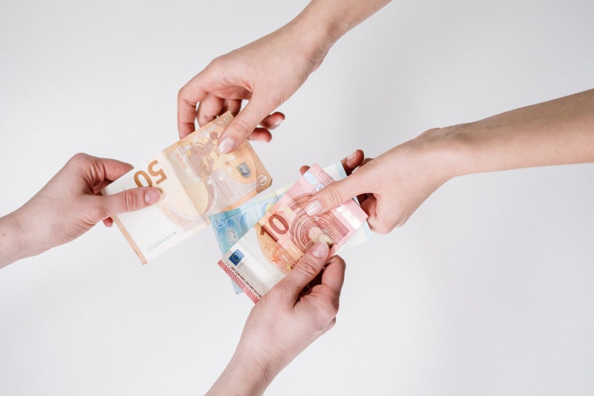 A group of people holding up money in their hands.